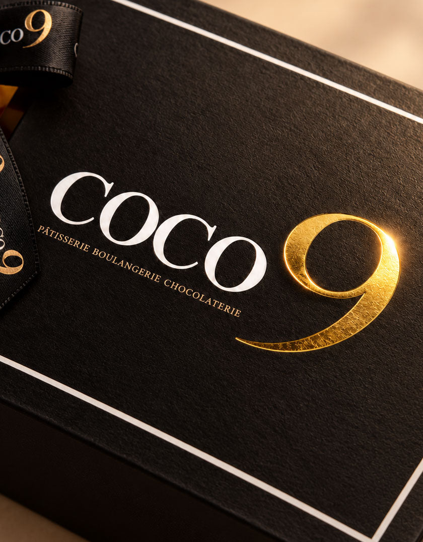 Straight-on close-up of the gold Coco 9 lettering on a closed box lid, catching light.